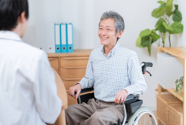 車いすのシニア男性とスタッフ